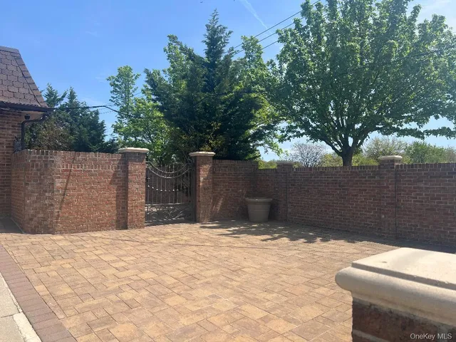 a view of backyard with wooden fence and large trees