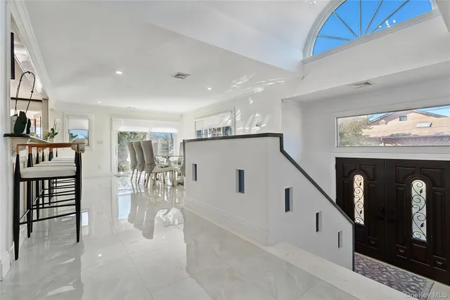 a hallway with white cabinets and outdoor seating