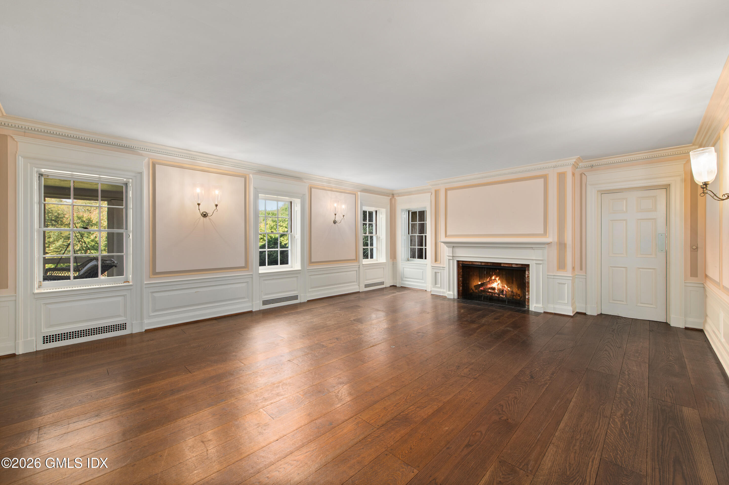 122 Round Hill Road Greenwich, CT 06831 - Photo 10 of 37 an empty room with wooden floor fireplace and windows