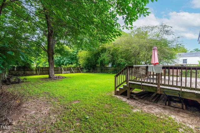an aerial view of a house with outdoor space and trees all around