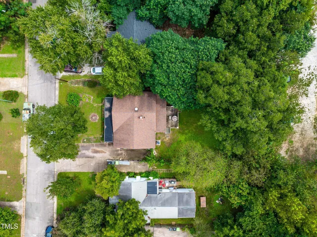 a view of a house with backyard and a tree