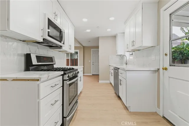 a kitchen with stainless steel appliances a stove microwave and refrigerator