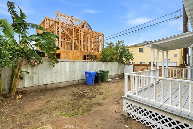 a view of a house with a small yard and wooden fence