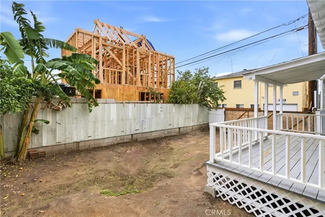 a view of a house with a small yard and wooden fence