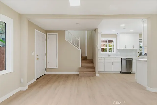 a kitchen with white cabinets and sink