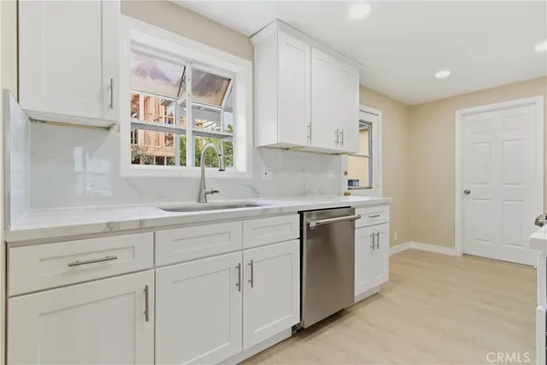 a kitchen with white cabinets and white appliances