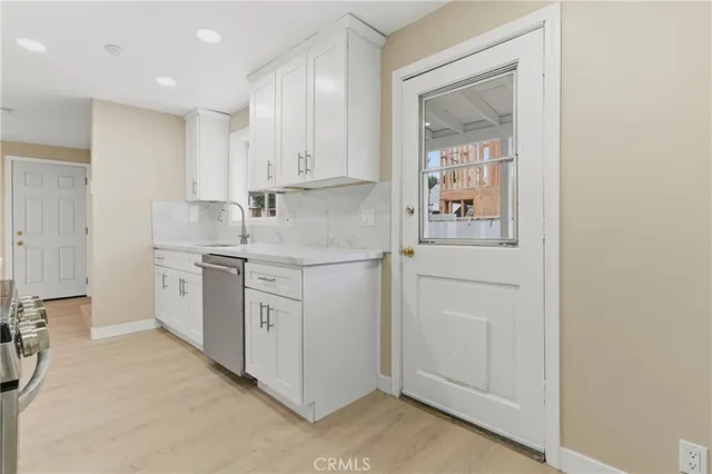 a kitchen with stainless steel appliances white cabinets and a stove top oven