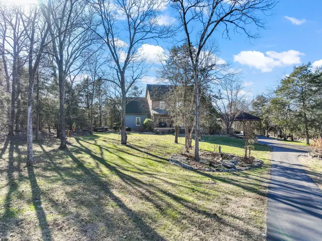 a view of a backyard with table and chairs under an umbrella
