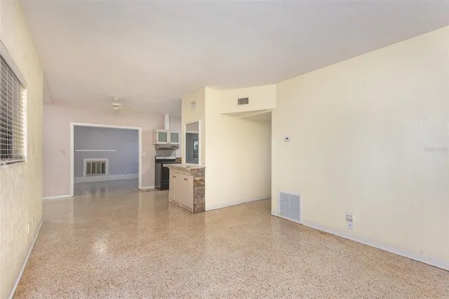 a view of empty room with kitchen