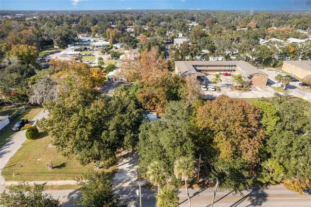 an aerial view of residential houses with outdoor space and trees
