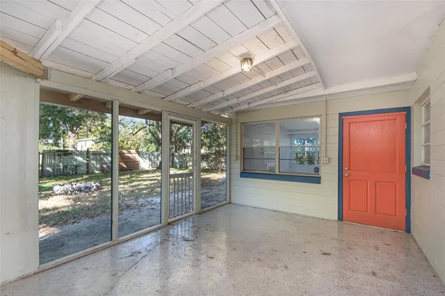 a view of empty room with floor to ceiling window and ceiling fan