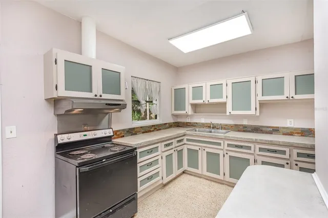 a kitchen with stainless steel appliances granite countertop a stove and a sink
