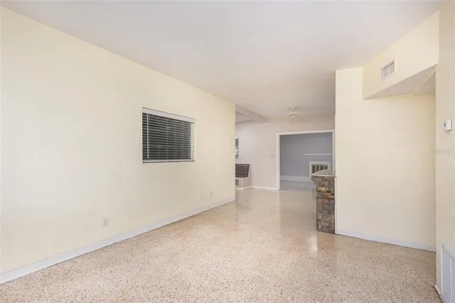 an empty room with windows and cabinet
