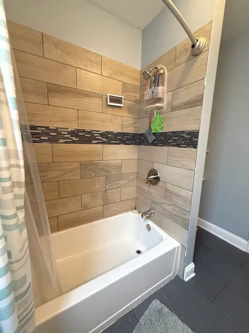 a bathroom with a bathtub and shower