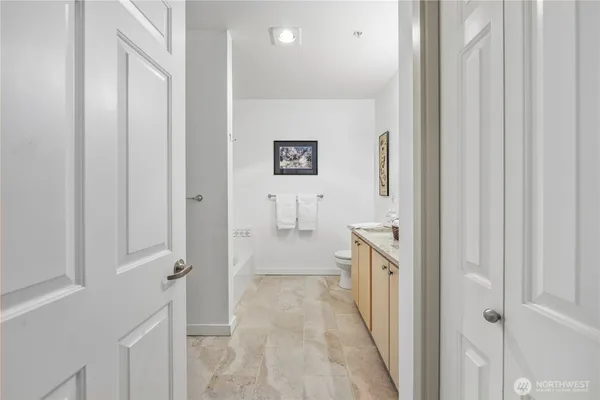a bathroom with a granite countertop sink a toilet and a mirror