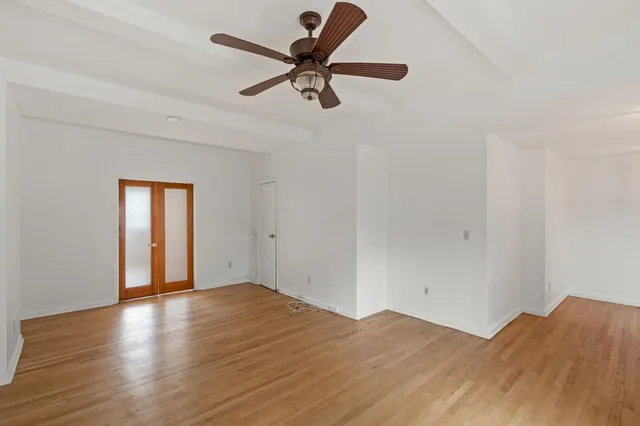a view of empty room with wooden floor