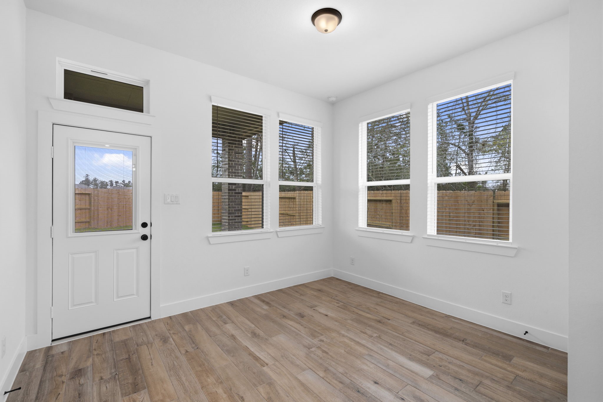 12806 Meadow Wind Way Conroe, TX 77302 - Photo 13 of 37 a view of an empty room with wooden floor and a window