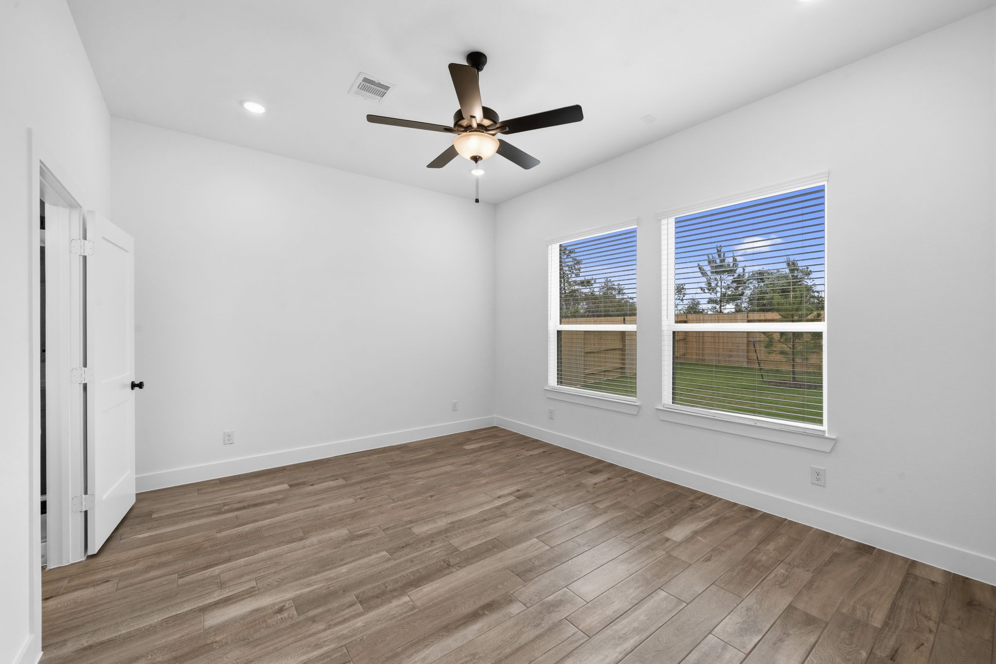 12806 Meadow Wind Way Conroe, TX 77302 - Photo 15 of 37 a view of an empty room with wooden floor and a window
