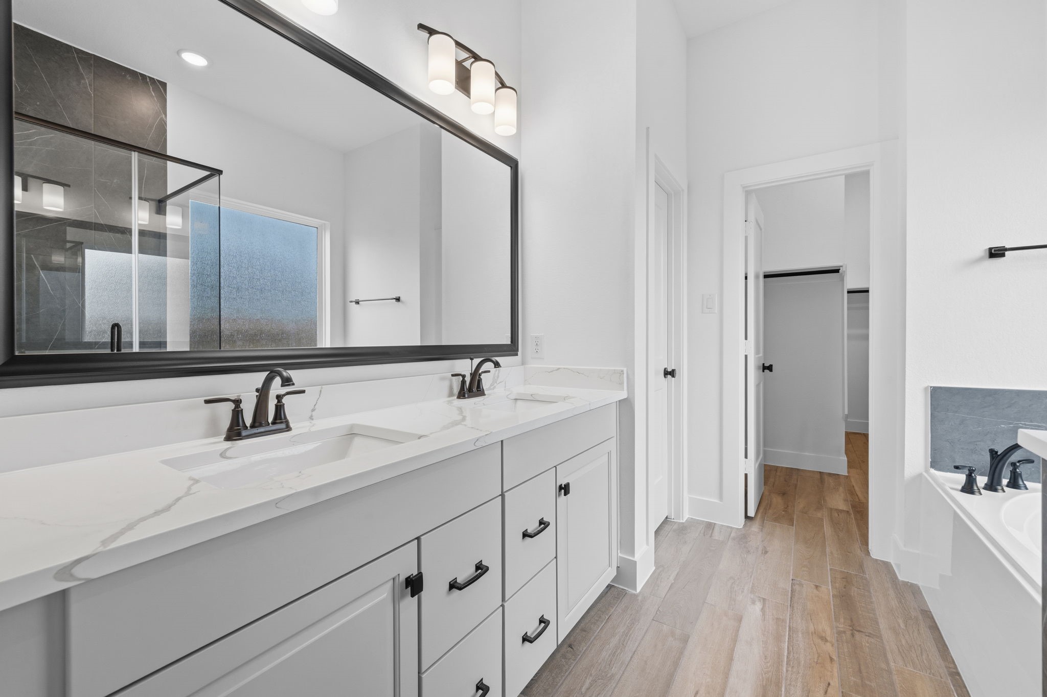 12806 Meadow Wind Way Conroe, TX 77302 - Photo 18 of 37 a spacious bathroom with a double vanity sink a mirror and a bathtub