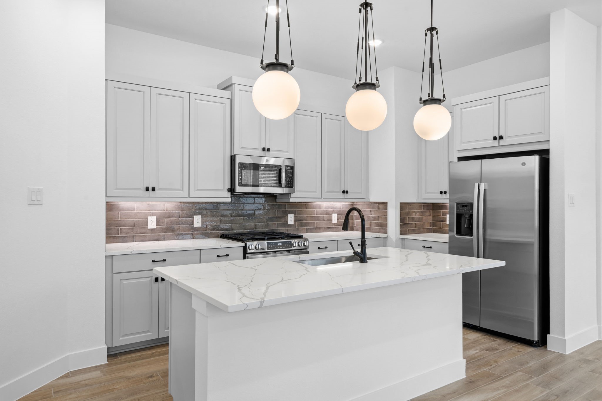 12806 Meadow Wind Way Conroe, TX 77302 - Photo 2 of 37 a kitchen with stainless steel appliances a stove a sink and a chandelier
