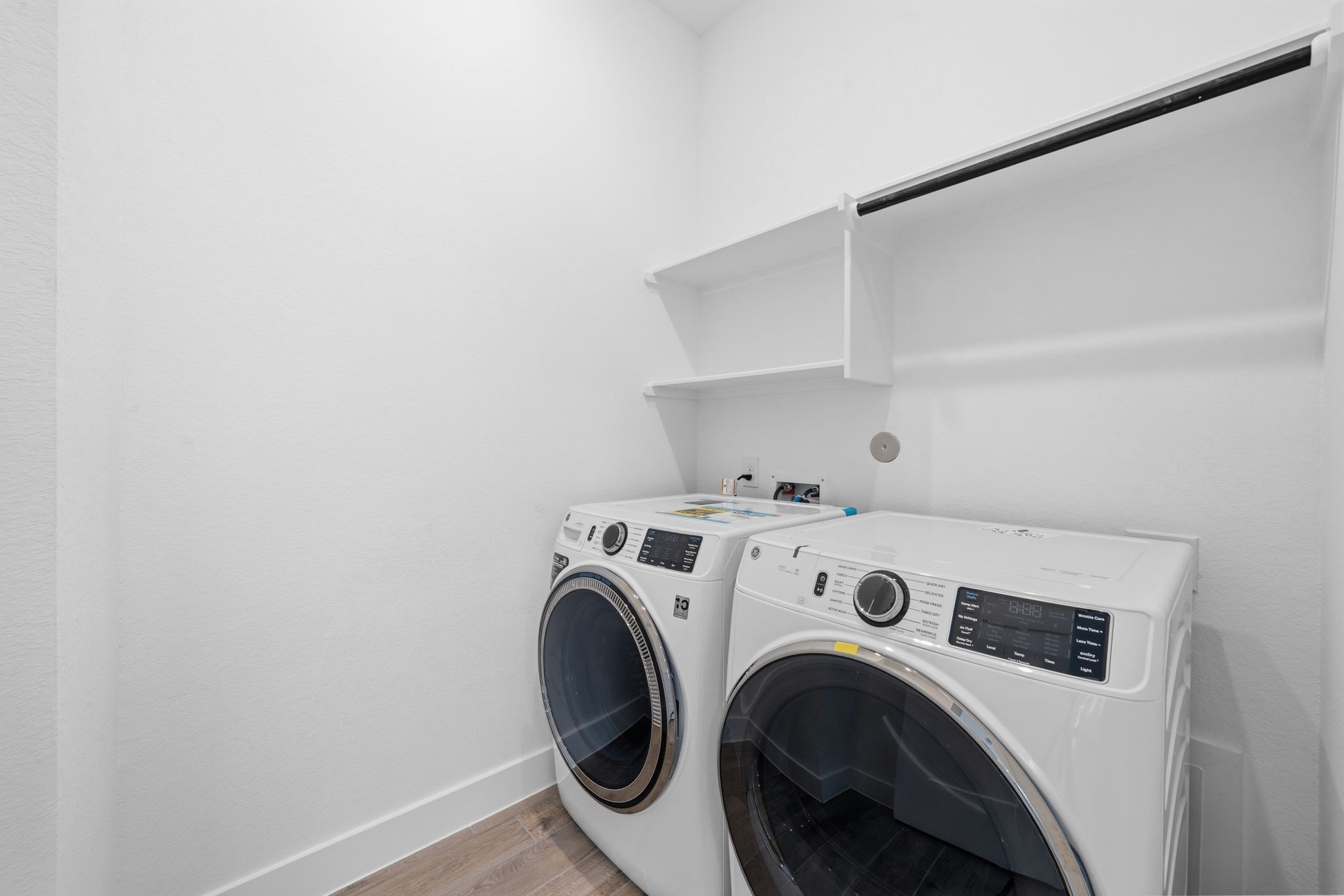12806 Meadow Wind Way Conroe, TX 77302 - Photo 22 of 37 a view of washer and dryer with kitchen in the background
