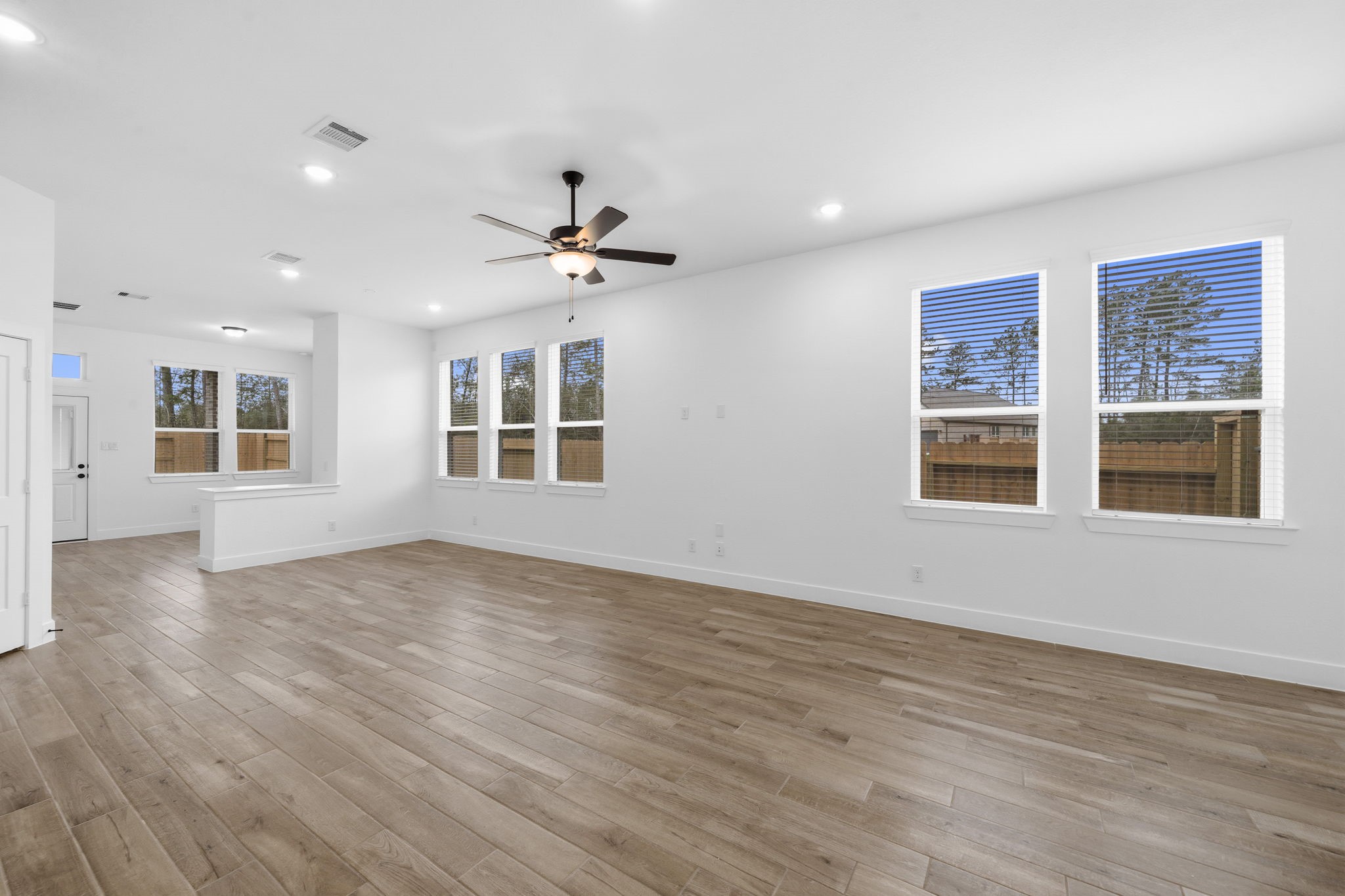 12806 Meadow Wind Way Conroe, TX 77302 - Photo 7 of 37 a view of an empty room with a window and wooden floor