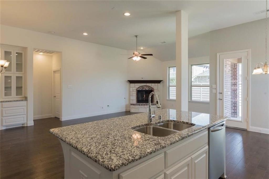 867 Forest Street Little Elm, TX 76227 - Photo 10 of 22 a kitchen with a granite countertop sink and chandelier