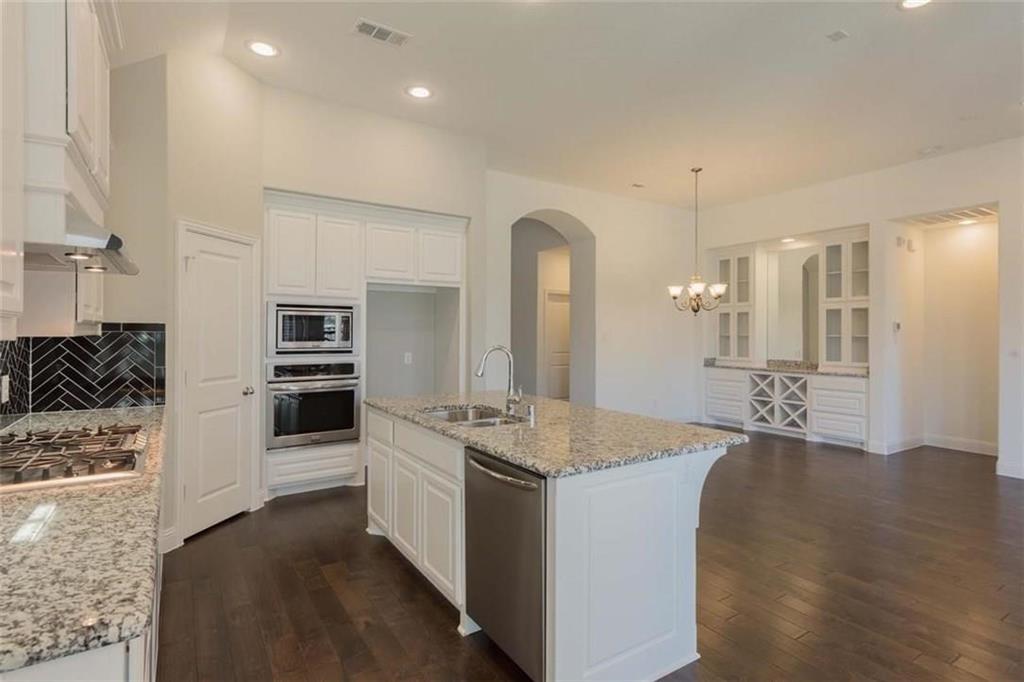 867 Forest Street Little Elm, TX 76227 - Photo 11 of 22 a kitchen with stainless steel appliances granite countertop a sink stove and refrigerator