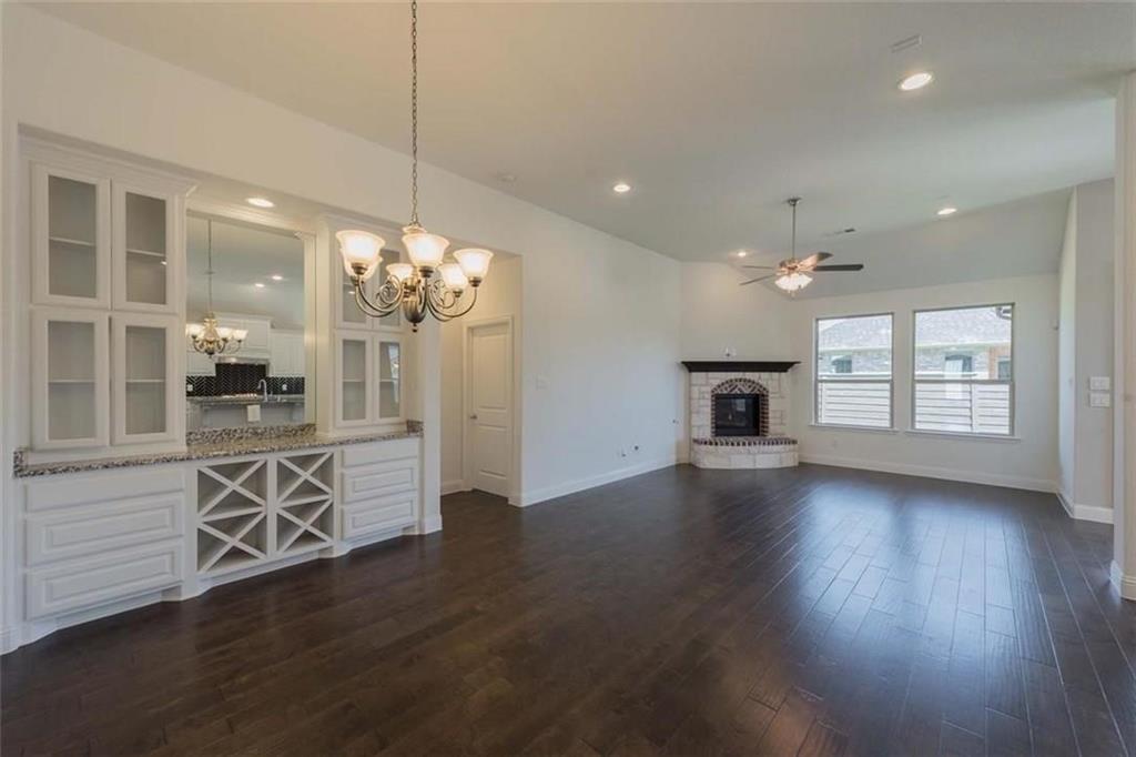 867 Forest Street Little Elm, TX 76227 - Photo 5 of 22 a view of a kitchen with granite countertop wooden floor and a refrigerator