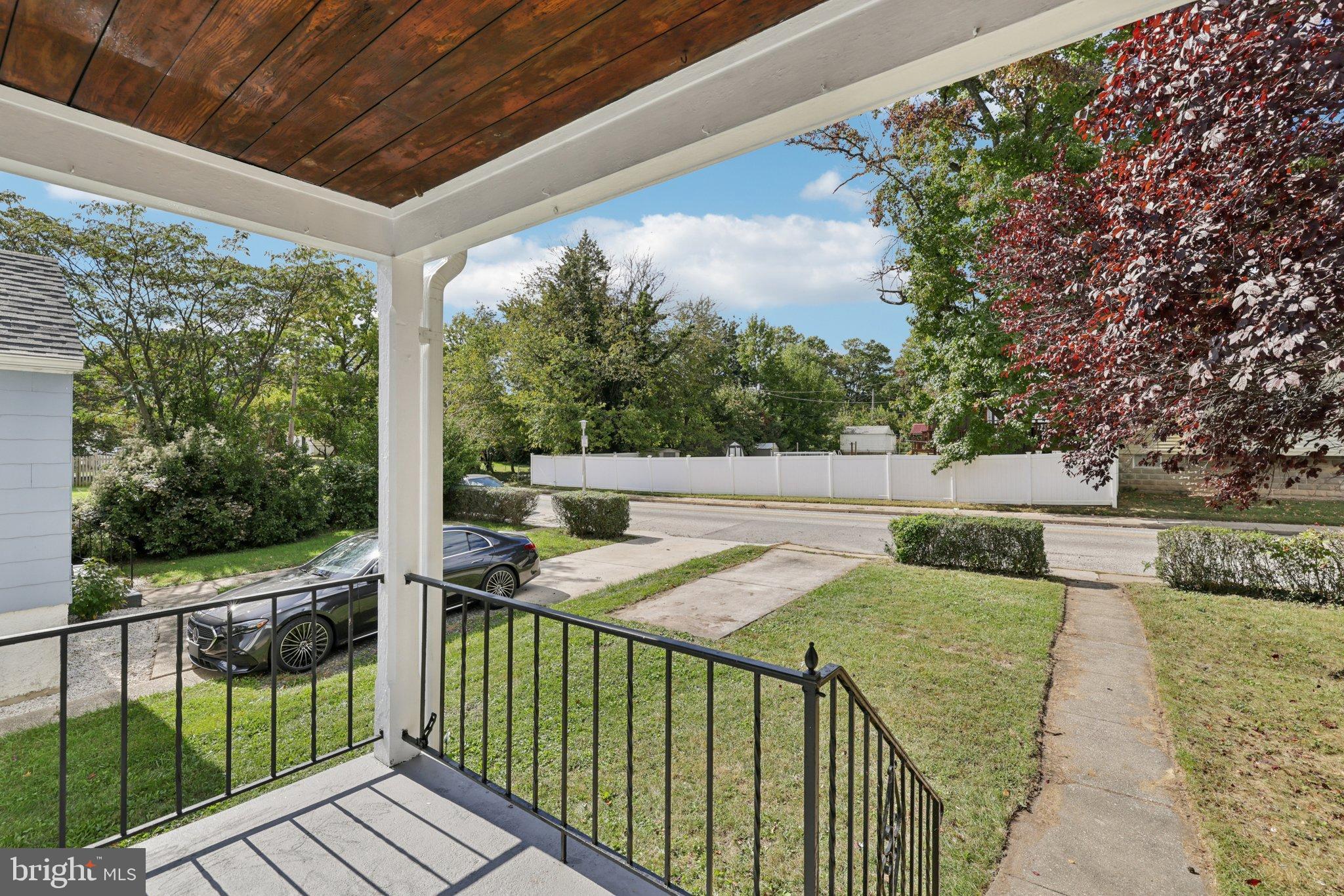 6907 Moyer Avenue Baltimore, MD 21234 - Photo 6 of 48 Charming porch view with lush greenery.