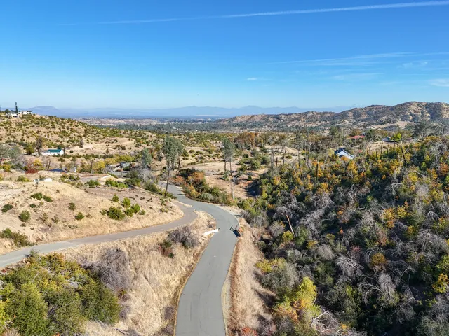 a view of a dry yard with a house in the background