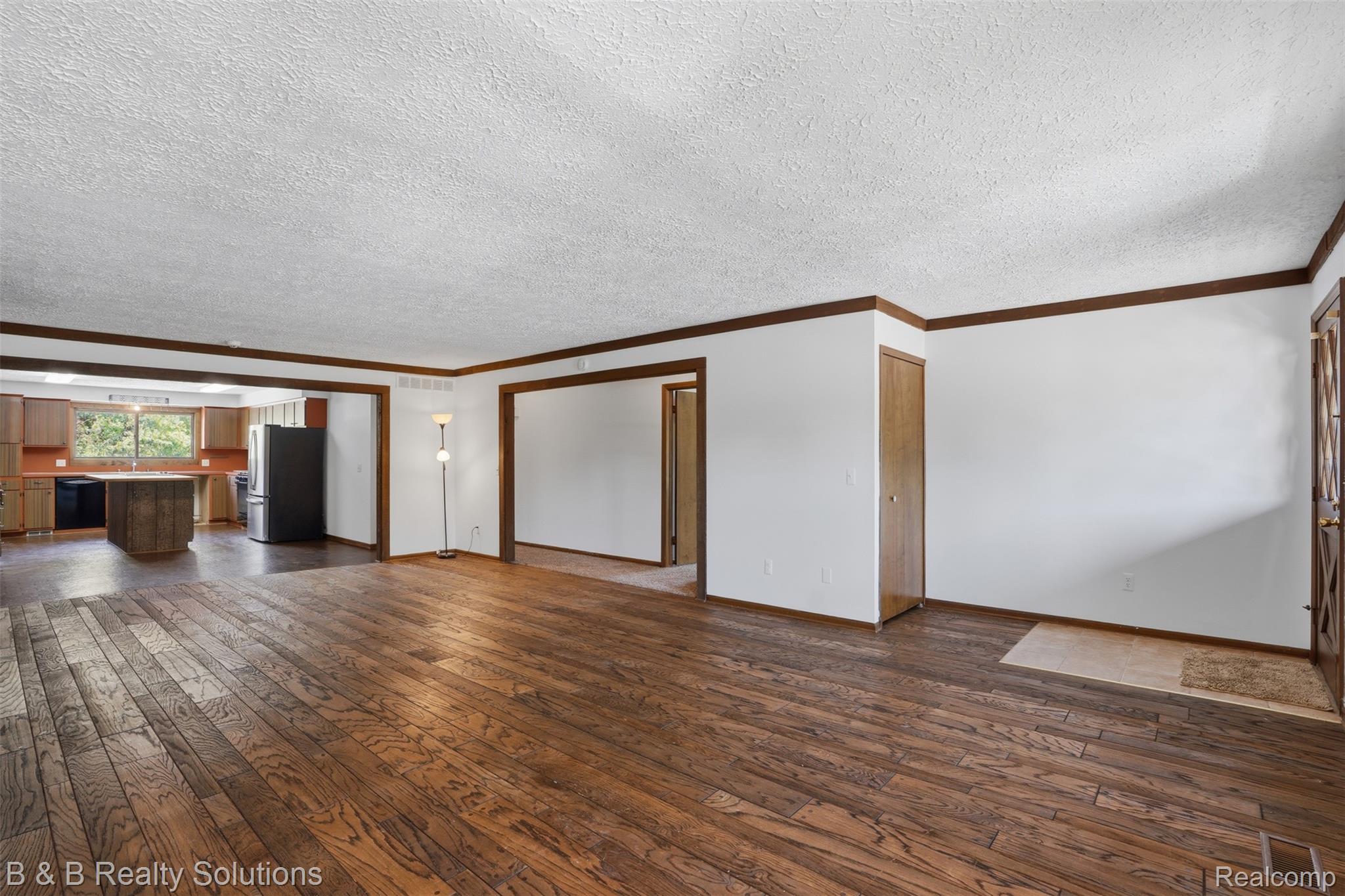 780 North Van Dyke Road, Unit APARTMENT #1 Almont, MI 48003 - Photo 7 of 28 Expansive interior space featuring wood-finish flooring, white walls, and dark wood trim