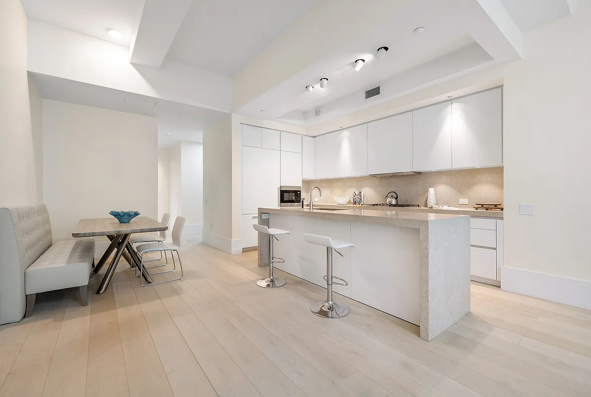 404 Park Avenue South, Unit 8/D Manhattan, NY 10016 - Photo 4 of 15 a kitchen with white cabinets and chairs