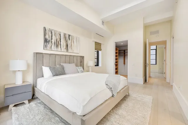 a large bed sitting in a bedroom and a table