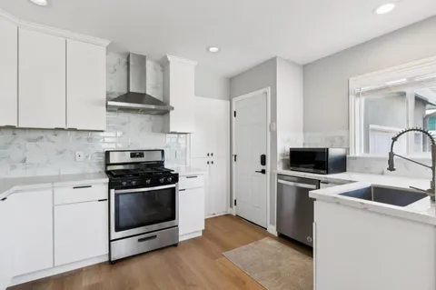 a kitchen with stainless steel appliances a stove a sink and a refrigerator
