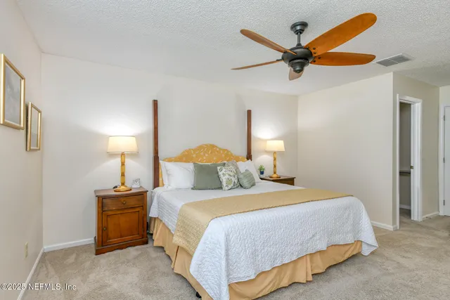 a bedroom with a bed a dresser and a chandelier