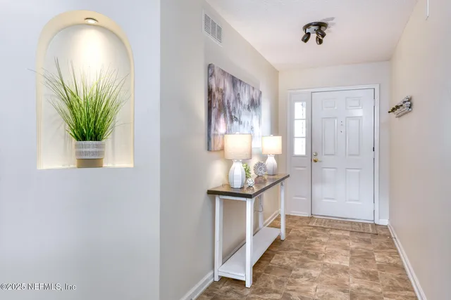 a view of a hallway with wooden floor and a bathroom