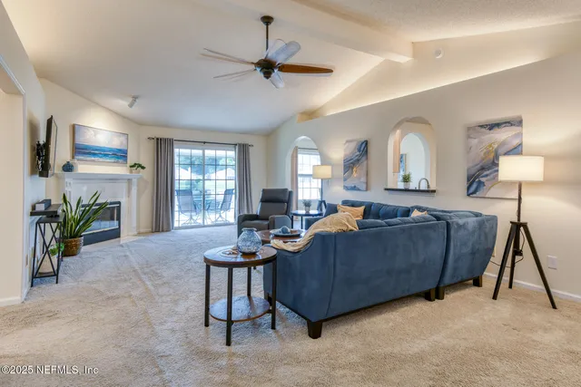 a living room with furniture a chandelier and a flat screen tv