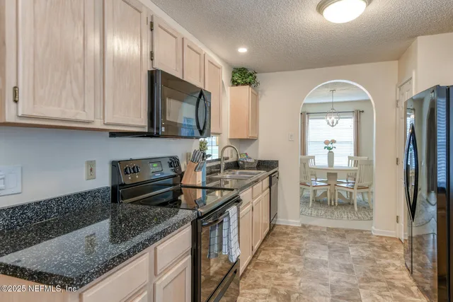 a kitchen with stainless steel appliances granite countertop a refrigerator and a sink