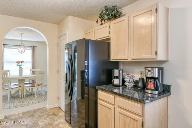 a kitchen with stainless steel appliances granite countertop a sink a stove and a refrigerator