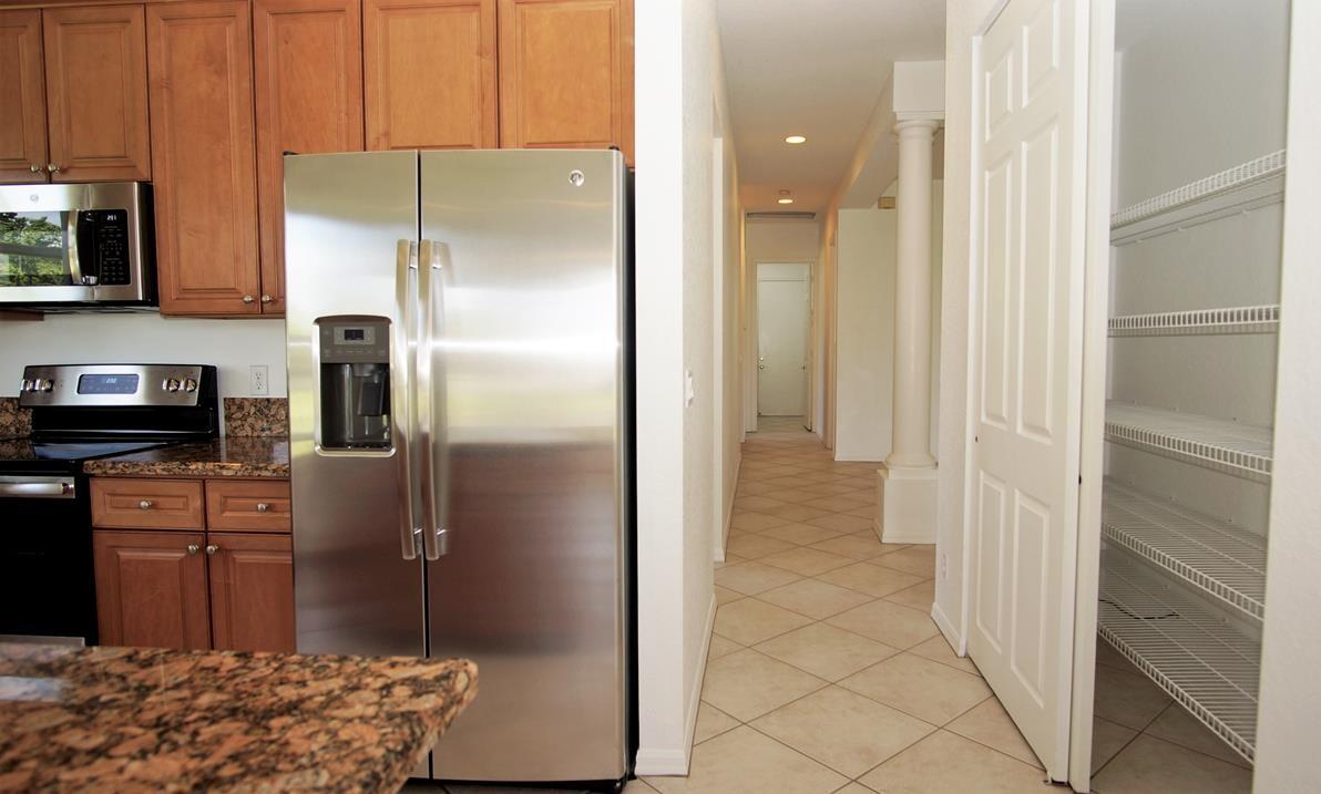 4688 Manderly Drive Wellington, FL 33449 - Photo 24 of 55 a kitchen with a refrigerator and a stove top oven