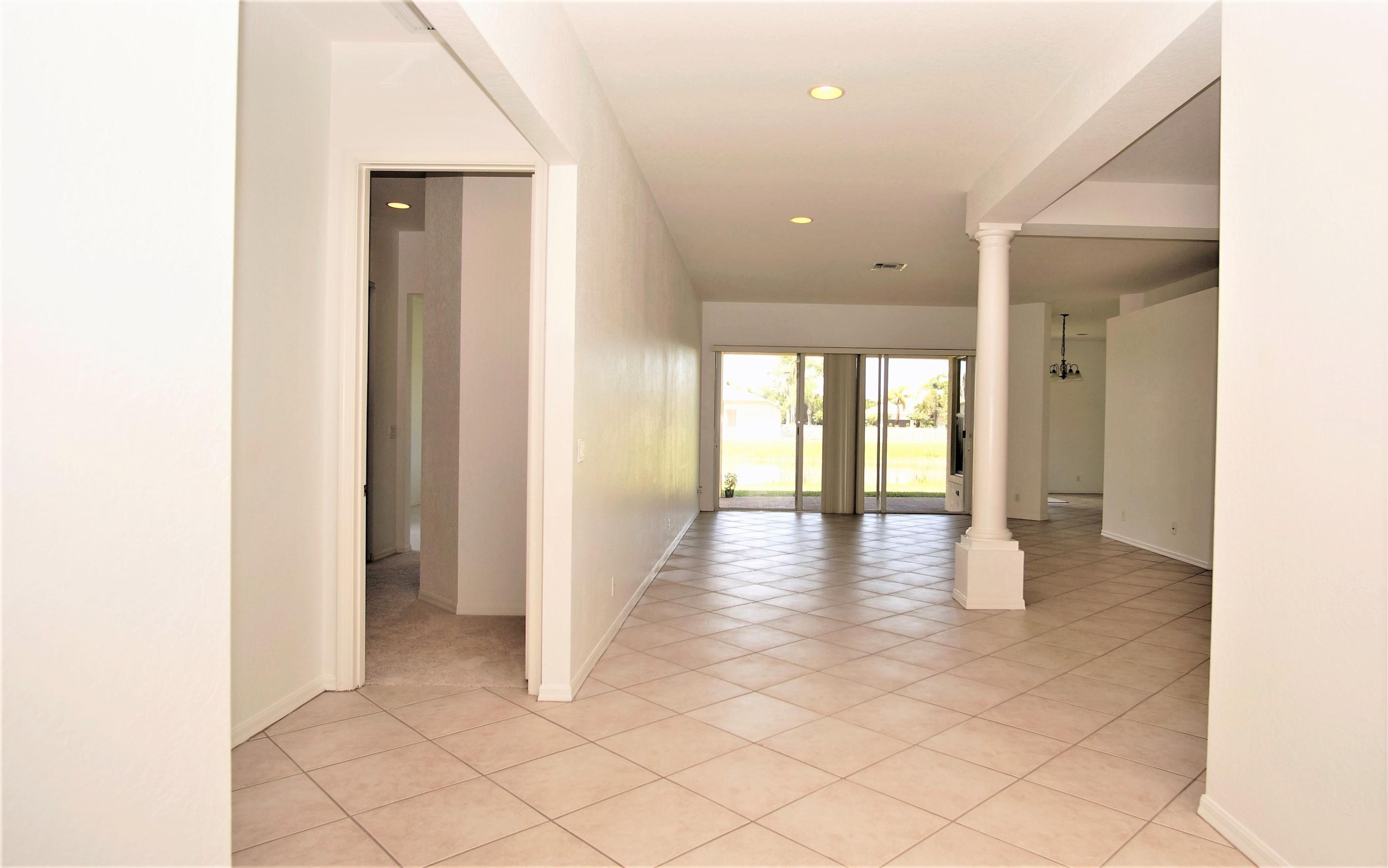 4688 Manderly Drive Wellington, FL 33449 - Photo 26 of 55 a view of a hallway with wooden floor and glass door