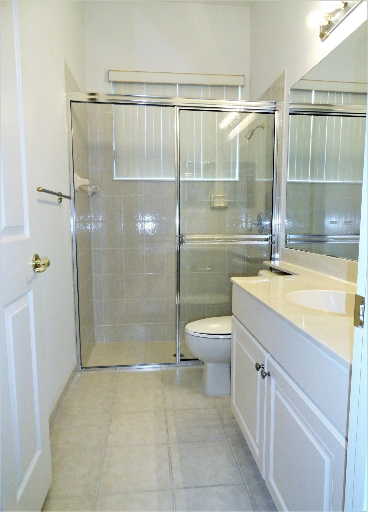 4688 Manderly Drive Wellington, FL 33449 - Photo 32 of 55 a bathroom with a shower a toilet and sink