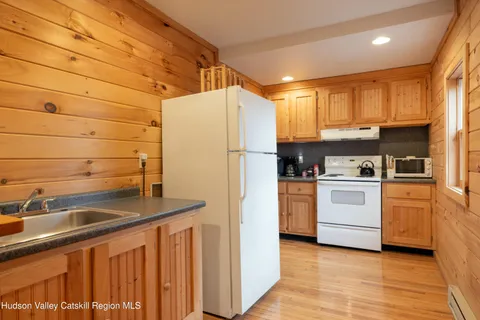 a kitchen with granite countertop a sink cabinets stainless steel appliances and a window
