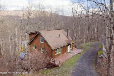 a view of a house with a yard and large tree