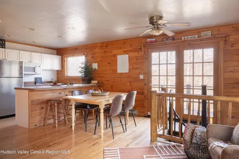 a dining room with wooden floor a chandelier a wooden table and chairs