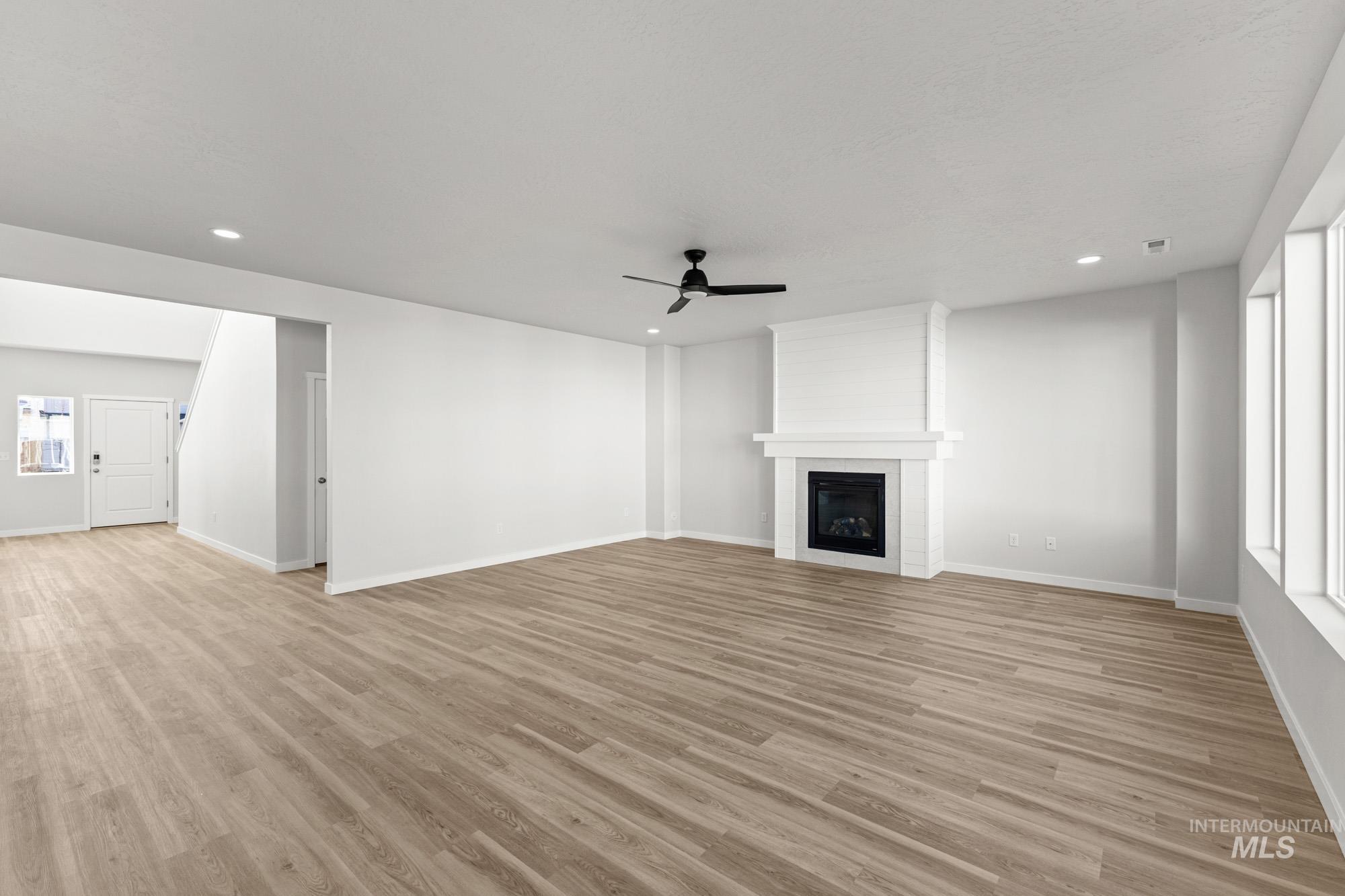 13708 Judson Street Caldwell, ID 83607 - Photo 10 of 29 Unfurnished living room featuring ceiling fan, light wood-type flooring, a large fireplace, and recessed lighting