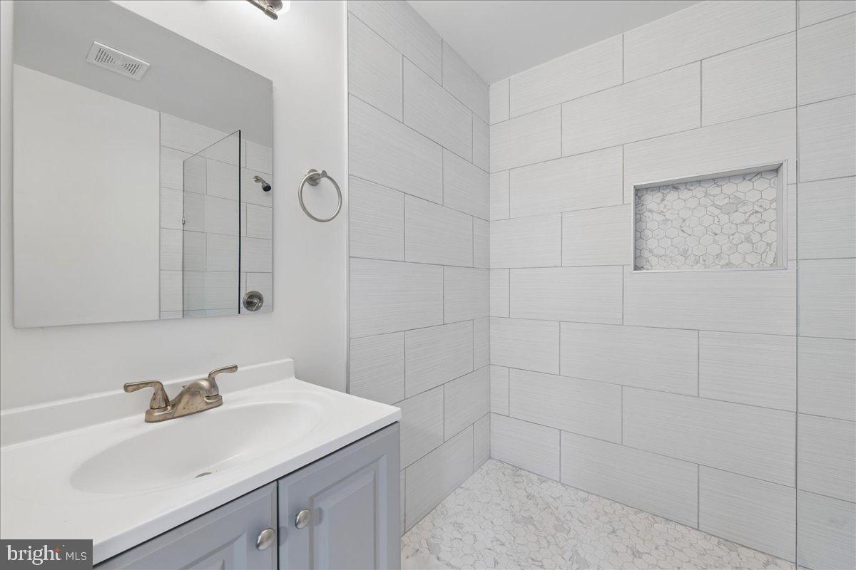 16206 Ashbox Road Brandywine, MD 20613 - Photo 23 of 30 Sleek modern bathroom with elegant tiles.