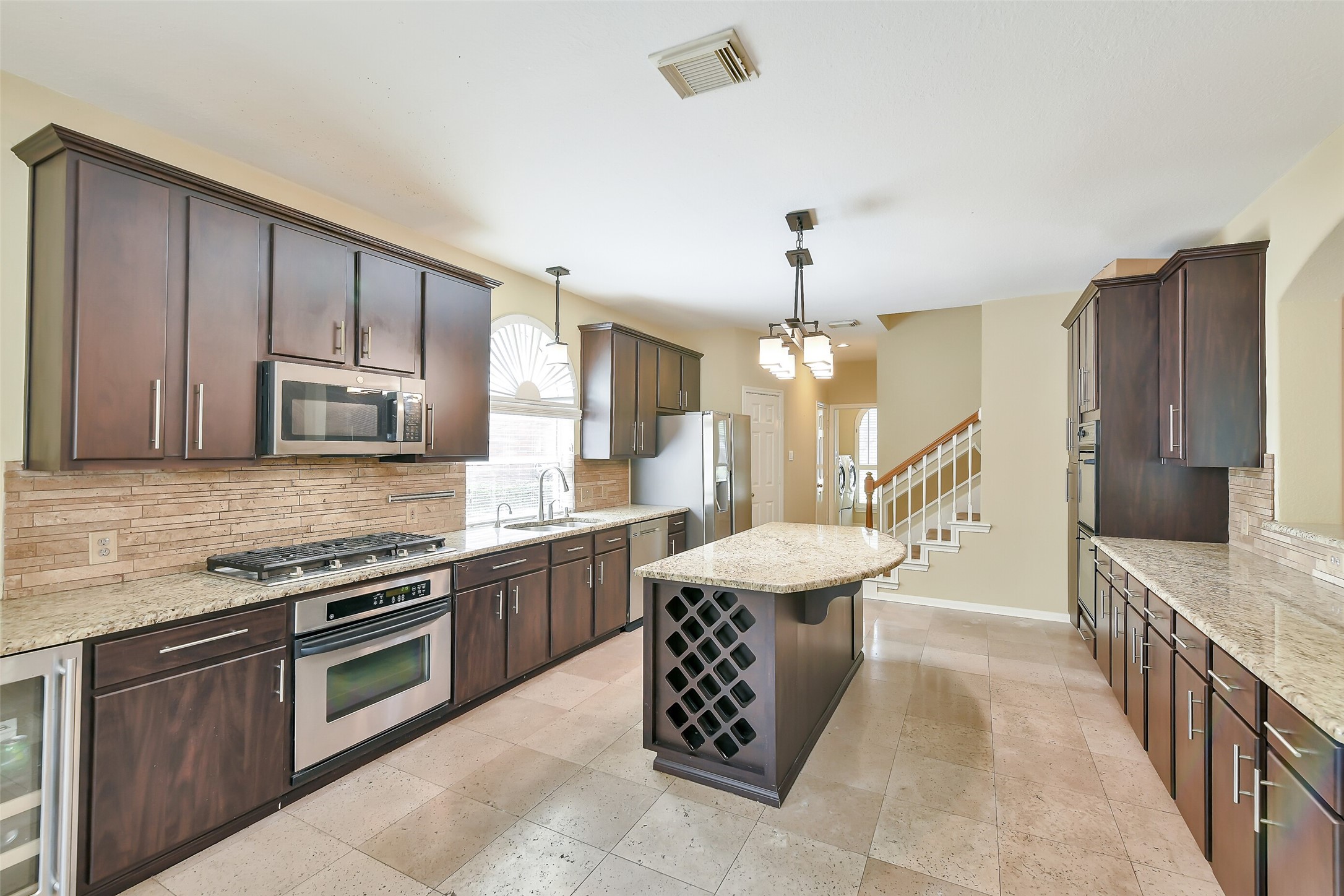 5803 Song Ridge Court Houston, TX 77041 - Photo 7 of 45 a kitchen with a sink stove and wooden cabinets