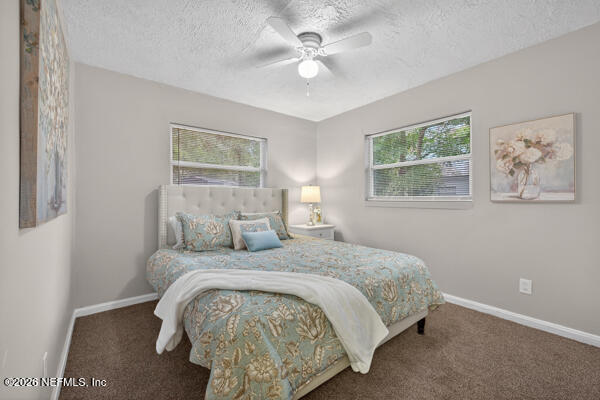 7143 King Arthur Road North Jacksonville, FL 32211 - Photo 11 of 18 a bedroom with a large bed and a chandelier